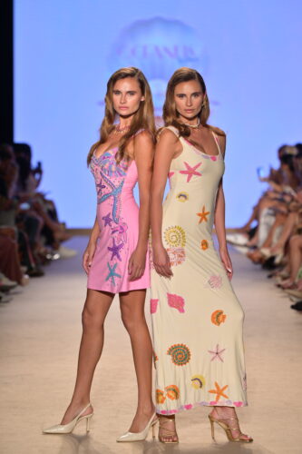 Olivia and Madeline Magruder walking in Oceanus’ ‘Sol del Trópico’ collection for the “Oceanus x Sojos” runway show at Paraiso Miami Swim Week 2025, wearing the Crescent Shell mini dress and the New York maxi dress – Photo by Simon Soong, courtesy of Paraiso and Miami Swim Week
