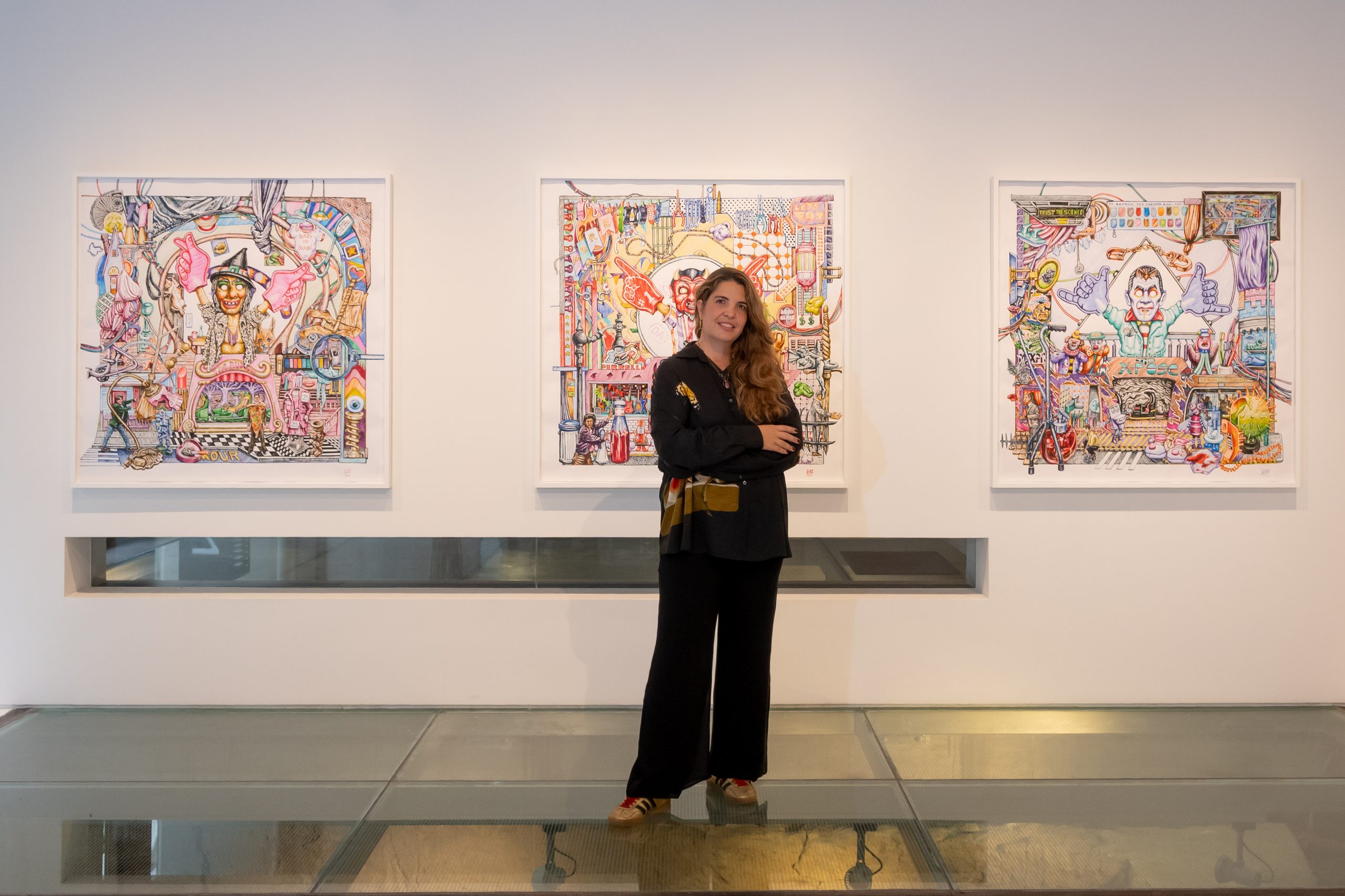 Marina Vranopoulou, founder of Dio Horia, standing in front of Elias Kafouros artworks at her contemporary art gallery in Athens.